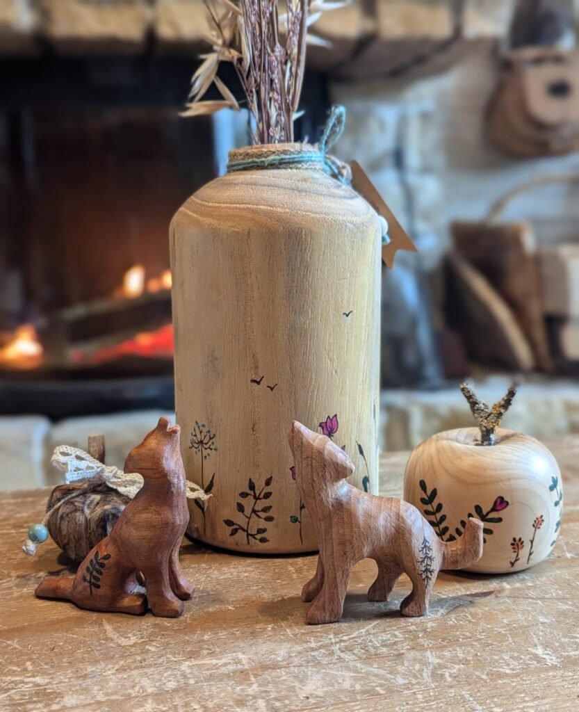 composition avec un pot rt une pomme en bois pyrogravés et 2 loups hurlants