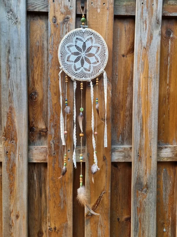 Détail du napperon délicat tissé au crochet et des perles bois et céramique colorées