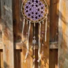 Détail des franges en tissu insérées entre les perles en bois et les plumes