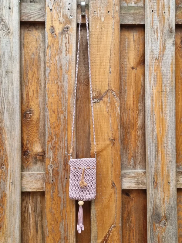 Gros plan du pompon et de la perle en bois ornait le bas de la pochette macramé
