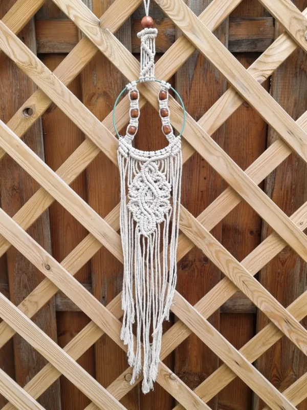 Motif tressé en coton blanc avec perle en bois supérieure et franges découpées au bas
