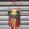Petite suspension macramé bambou fait main avec motif feuilles vert foncé et fond jaune et rouge
