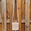 pochette blanche et fleur 2 Détail des motifs de fleurs couleur vieux rose tressés sur le macramé blanc