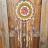 Détail du napperon fleur rouge tissé à la main sur cerclage bois avec perles en bois et céramique