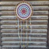 Attrape-rêves motif soleil centre brique et rayons jaunes sur cerclage en bois avec perles en céramique et plumes