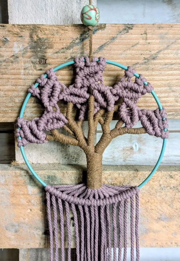 mac cerclage acier vert arbre rose Détail du tressage du tronc brun et des feuilles roses en macramé fait main sur cercle vert