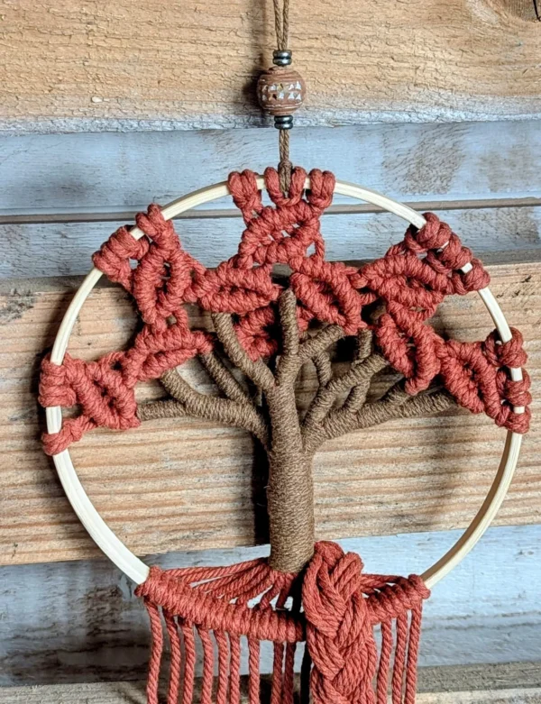 Détail du tressage brique autour du cerclage en bois et des franges retombantes en macramé fait main
